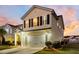Two-story house with a beige exterior, a white garage door, and a landscaped front yard at 108 Glenspring Dr, Summerville, SC 29486