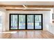 Living room with hardwood floors, black sliding doors opening to backyard, and white built-ins at 3894 Summerton St, Mount Pleasant, SC 29466