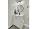 Small bathroom with white vanity, black fixtures, and a round mirror at 700 Kilarney Rd, Summerville, SC 29483
