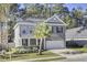 Two-story home with gray brick and white trim, featuring a front porch and attached garage at 700 Kilarney Rd, Summerville, SC 29483