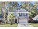 Two-story home with gray brick and white trim, featuring a front porch and attached garage at 700 Kilarney Rd, Summerville, SC 29483