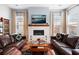 Relaxing living room with a fireplace, comfortable leather sofas, and large windows at 104 True Blue, Summerville, SC 29486