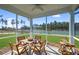 Relaxing screened porch overlooking a pond with wooden furniture and a drink cart at 137 Winding Grove Ln, Moncks Corner, SC 29461