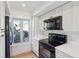 Modern kitchen with white cabinets, black appliances, and a window overlooking a deck at 1505 Marsh Haven, Johns Island, SC 29455
