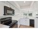 Modern kitchen with white shaker cabinets, black appliances, and quartz countertops at 1505 Marsh Haven, Johns Island, SC 29455