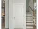 Entryway with white door, stairs, and view into the kitchen at 2257 Blue Bayou Blvd, Johns Island, SC 29455