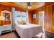 Bedroom with wood paneling, a queen bed, and natural light at 3131 Palmetto Blvd, Edisto Island, SC 29438