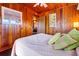 Bedroom with wood paneling, a queen bed, and soft lighting at 3131 Palmetto Blvd, Edisto Island, SC 29438