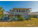 Beach house exterior with elevated deck, sunlit lawn and ample parking at 3131 Palmetto Blvd, Edisto Island, SC 29438