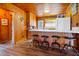 Kitchen with wood paneled walls, breakfast bar with four stools, and white appliances at 3131 Palmetto Blvd, Edisto Island, SC 29438