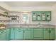 Updated kitchen with green cabinets, granite counters, and herringbone backsplash at 3264 Stonehaven Dr, North Charleston, SC 29420