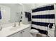 Clean bathroom with white vanity and striped shower curtain at 204 Michigan Ave # C3, Folly Beach, SC 29439