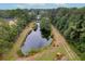 Aerial view of a pond near a wooded area and construction equipment at 3034 Cane Slash Rd, Johns Island, SC 29455