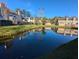 Tranquil pond reflecting townhouses in a community at 403 Reserve Way, Summerville, SC 29485