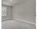 Empty bedroom with grey carpet, neutral walls, and a window with wooded view at 5629 Ellington School Rd, Ravenel, SC 29470
