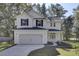 Two-story white house with black shutters, gray roof, and a two-car garage at 5629 Ellington School Rd, Ravenel, SC 29470