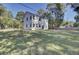 Two-story white house with a large backyard and wooden fence at 5629 Ellington School Rd, Ravenel, SC 29470