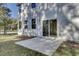 Rear view of a light grey house with a sliding glass door leading to a patio at 5629 Ellington School Rd, Ravenel, SC 29470