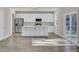 Modern kitchen with white cabinets, stainless steel appliances, and island at 5629 Ellington School Rd, Ravenel, SC 29470