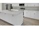 Kitchen island with white cabinets, quartz countertop, and gold hardware at 5629 Ellington School Rd, Ravenel, SC 29470