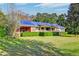 Brick ranch home with solar panels, spacious lawn, and mature trees at 185 Old Fort Dr, Ladson, SC 29456
