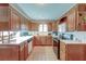 L-shaped kitchen with wood cabinets, tile flooring, and white countertops at 185 Old Fort Dr, Ladson, SC 29456
