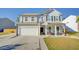 Gray two-story house with white garage door, porch, and American flag at 2009 Elvington Rd, Johns Island, SC 29455