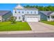 Two-story house with gray siding, white garage door, and landscaped lawn at 225 Sugarberry Ln, Moncks Corner, SC 29461