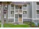 Gray multi-unit building with white railings and stairs, surrounded by palm trees and grass at 30 Mariners Cay Dr, Folly Beach, SC 29439