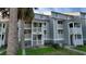 Gray multi-unit building with white railings and stairs, surrounded by palm trees and grass at 30 Mariners Cay Dr, Folly Beach, SC 29439