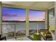 Relaxing screened porch with wicker furniture and stunning sunset views over the water at 30 Mariners Cay Dr, Folly Beach, SC 29439