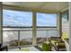 Relaxing screened porch with wicker furniture and view of houses across the water at 30 Mariners Cay Dr, Folly Beach, SC 29439
