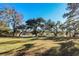 Expansive backyard with lush lawn and mature trees bordering the water at 4415 Lord Proprietors Rd, Hollywood, SC 29449