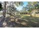 Sunny backyard with lush grass, trees, and a glimpse of water at 4415 Lord Proprietors Rd, Hollywood, SC 29449