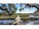 Wooden dock leading to marsh under large oak trees at 4415 Lord Proprietors Rd, Hollywood, SC 29449