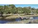 Wooden dock extending over calm water with marsh grasses at 4415 Lord Proprietors Rd, Hollywood, SC 29449