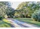 Landscaped front yard with a long driveway and mature trees at 4415 Lord Proprietors Rd, Hollywood, SC 29449