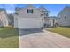 Two-story house with beige siding, white garage door, and manicured lawn at 488 Sanctuary Park Dr, Summerville, SC 29486