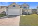 Two-story house with beige siding, white garage door, and manicured lawn at 488 Sanctuary Park Dr, Summerville, SC 29486