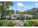 Front view of a charming white brick ranch house with a detached garage and gravel driveway at 825 Harbor View Rd, Charleston, SC 29412