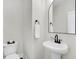 Modern powder room with pedestal sink and arched mirror at 105 Archdale St, Summerville, SC 29486