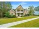 Two-story brick home with a front porch and well-maintained landscaping at 1068 Blockade Runner Pkwy, Summerville, SC 29485