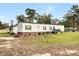 Another side view of the mobile home highlighting its size and landscaping at 113 Hill Drive, Summerville, SC 29483