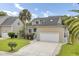 Two-story house with beige siding, two-car garage, and manicured lawn at 304 Wild Horse Ln, Mount Pleasant, SC 29464