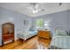 Charming bedroom with twin beds, hardwood floors, and a vintage wooden cabinet at 317 W Hudson Ave, Folly Beach, SC 29439