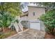Elevated home with a detached garage and wooden stairs leading to the entrance at 317 W Hudson Ave, Folly Beach, SC 29439