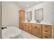 Elegant bathroom with double vanity, soaking tub, and marble floors at 592 Oyster Rake Dr, Kiawah Island, SC 29455