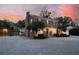 Charming brick home with landscaping, illuminated at dusk at 105 Folly Road Blvd, Charleston, SC 29407