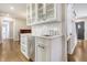 White kitchen with a built in bar area, quartz countertops and stainless steel appliances at 105 Folly Road Blvd, Charleston, SC 29407