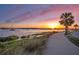 Scenic waterfront pathway at sunset with boats and palm trees at 105 Folly Road Blvd, Charleston, SC 29407